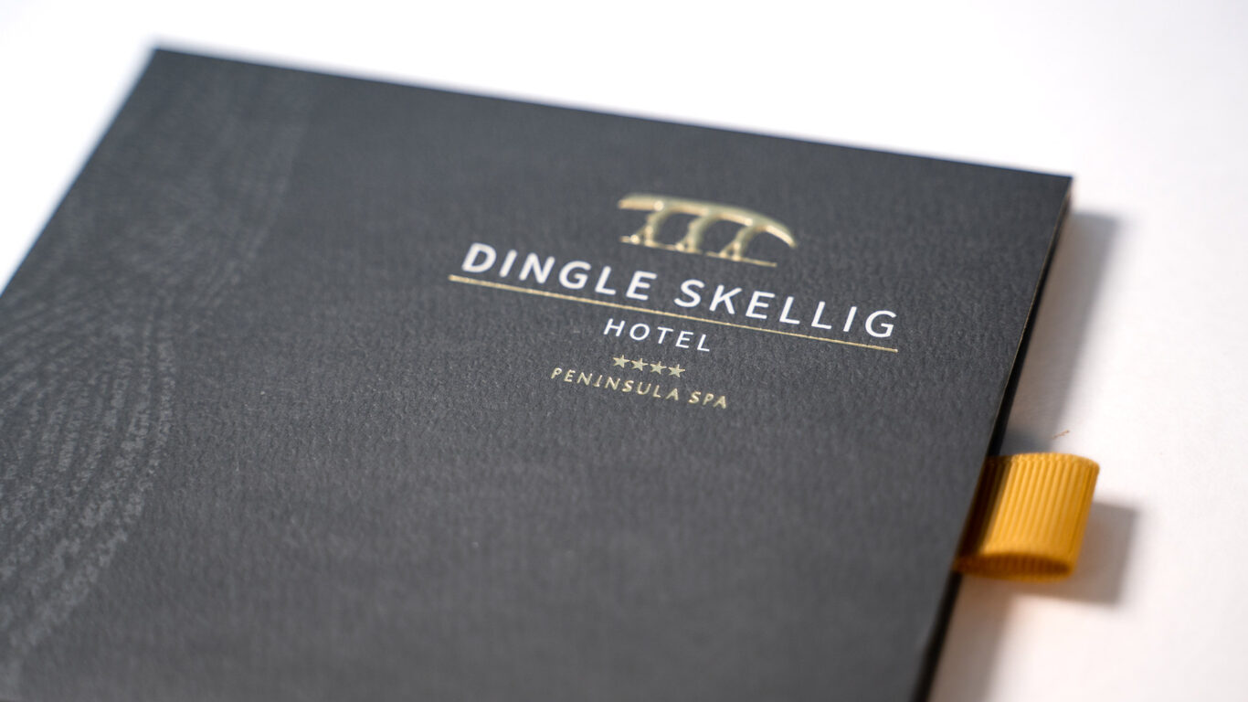 Close-up of a black folder with gold embossed text reading 