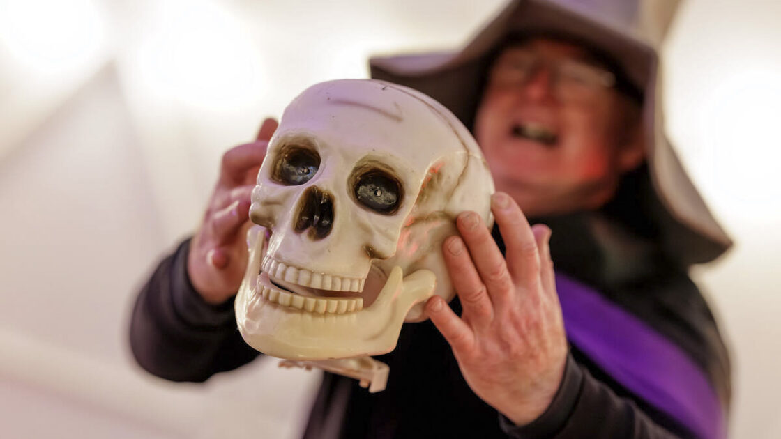 Enjoy a magical Halloween event with activities and themed decor at our hotel, featuring a host in a witch hat.