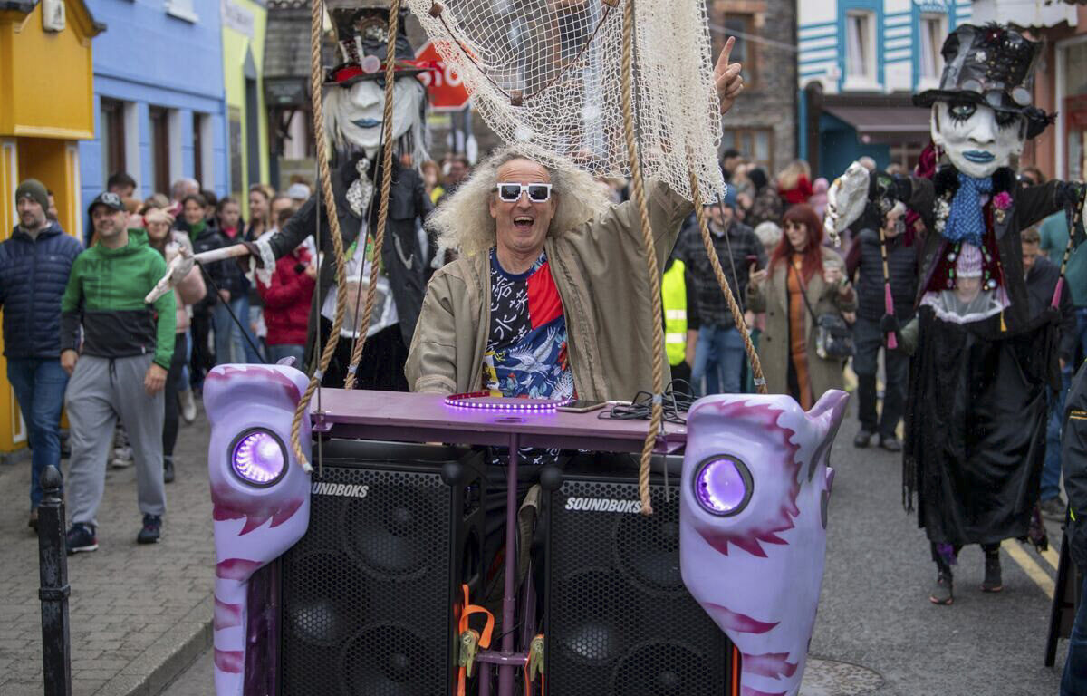 Festive parade with colourful costumes and lively music on vibrant street, capturing local culture near the hotel.